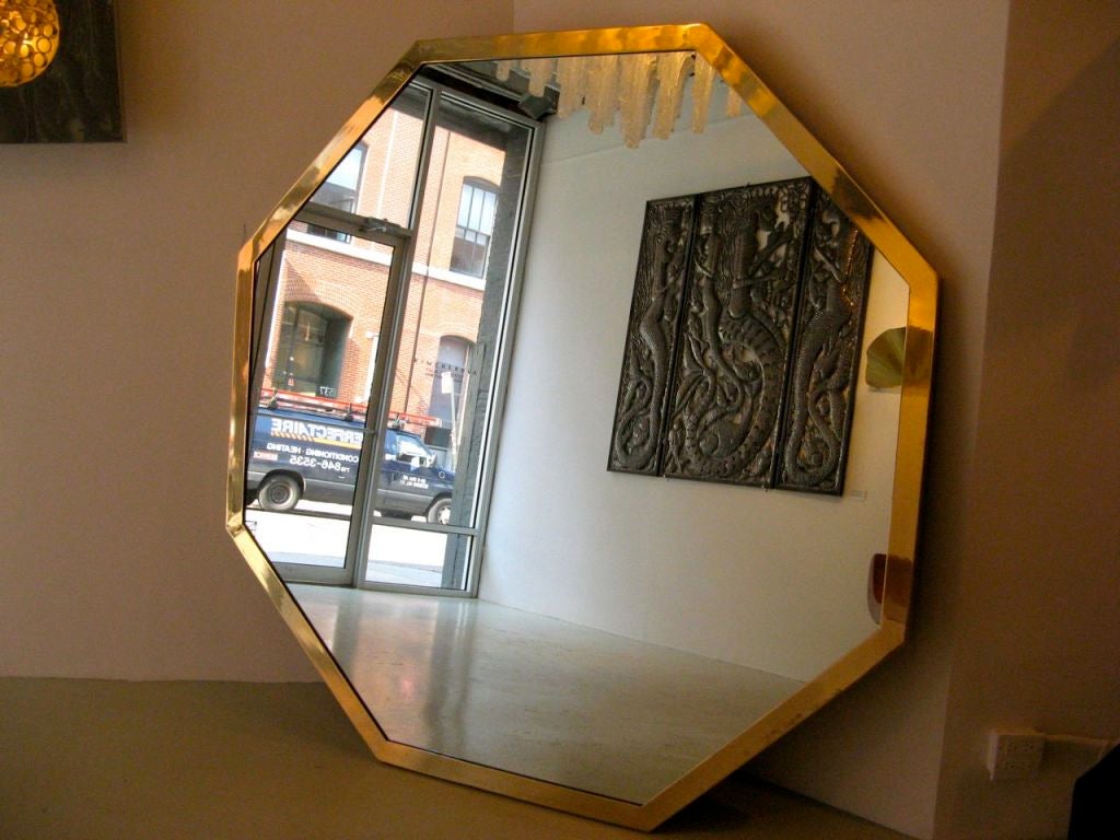 Large octagonal plate of mirrored glass framed with a band of polished brass by Maison Jansen, France, c. 1970.