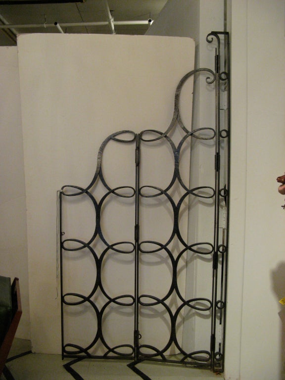Pair of wrought iron gates, fashioned in a repeating C - scroll design by Raymond Subes, France, c. 1930.
The gates can be oriented with hinges at either the tall or short side.