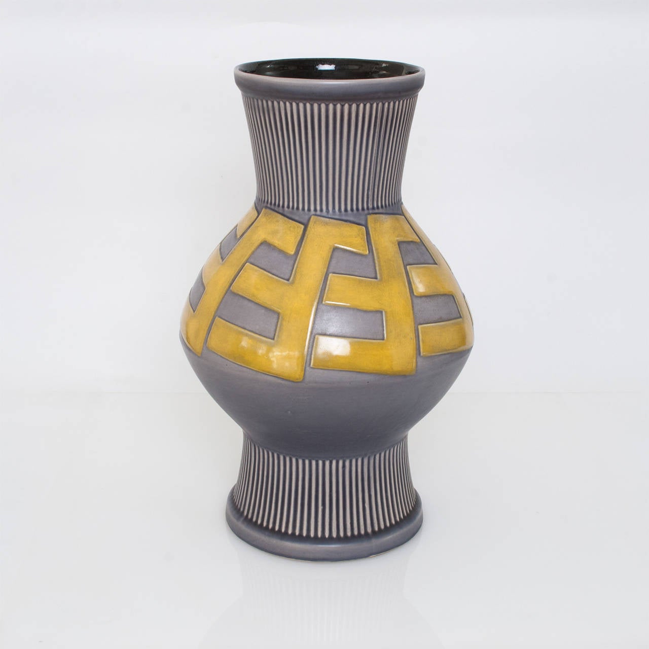 Swedish Art Deco ceramic vase with a raised bold pattern in a golden glaze on a grey or blue background. Designed by artist Ewald Dahlskog for Bo Fajans, circa 1930.