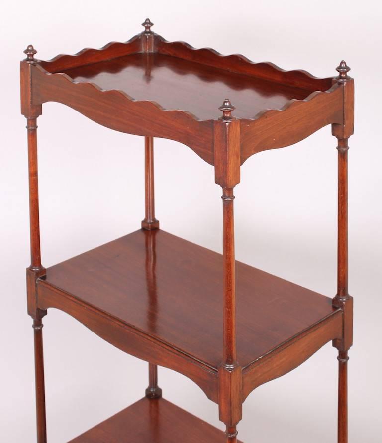 Rare George III period mahogany pyramid-form whatnot; the four graduated shelves with serpentine apron-pieces, fitted with an oak-lined drawer and with exceptionally slender turned supports.