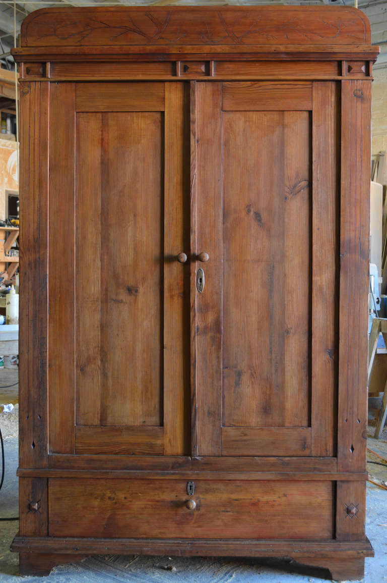 Country armoire with delicately carved Art Nouveau acorn design.