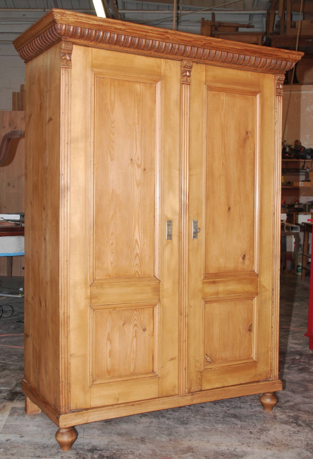 Elegantly understated armoire with a beautifully carved cornice and fluted pilasters. Has original hanging rod, but we can add shelves if needed.