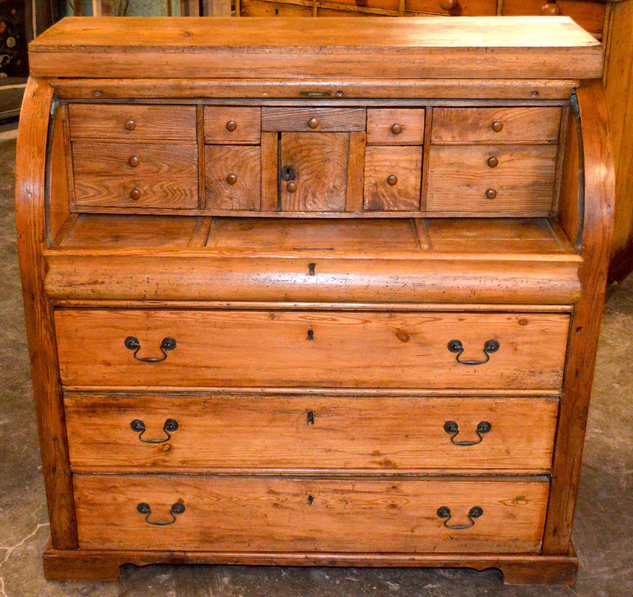 Exceptional cylinder top desk with great patina, complete and very original. 
Roll up the top to reveal ten smaller drawers and center door with lock. 
pull-out desktop with adjustable reading Stand in center and covered compartments on either