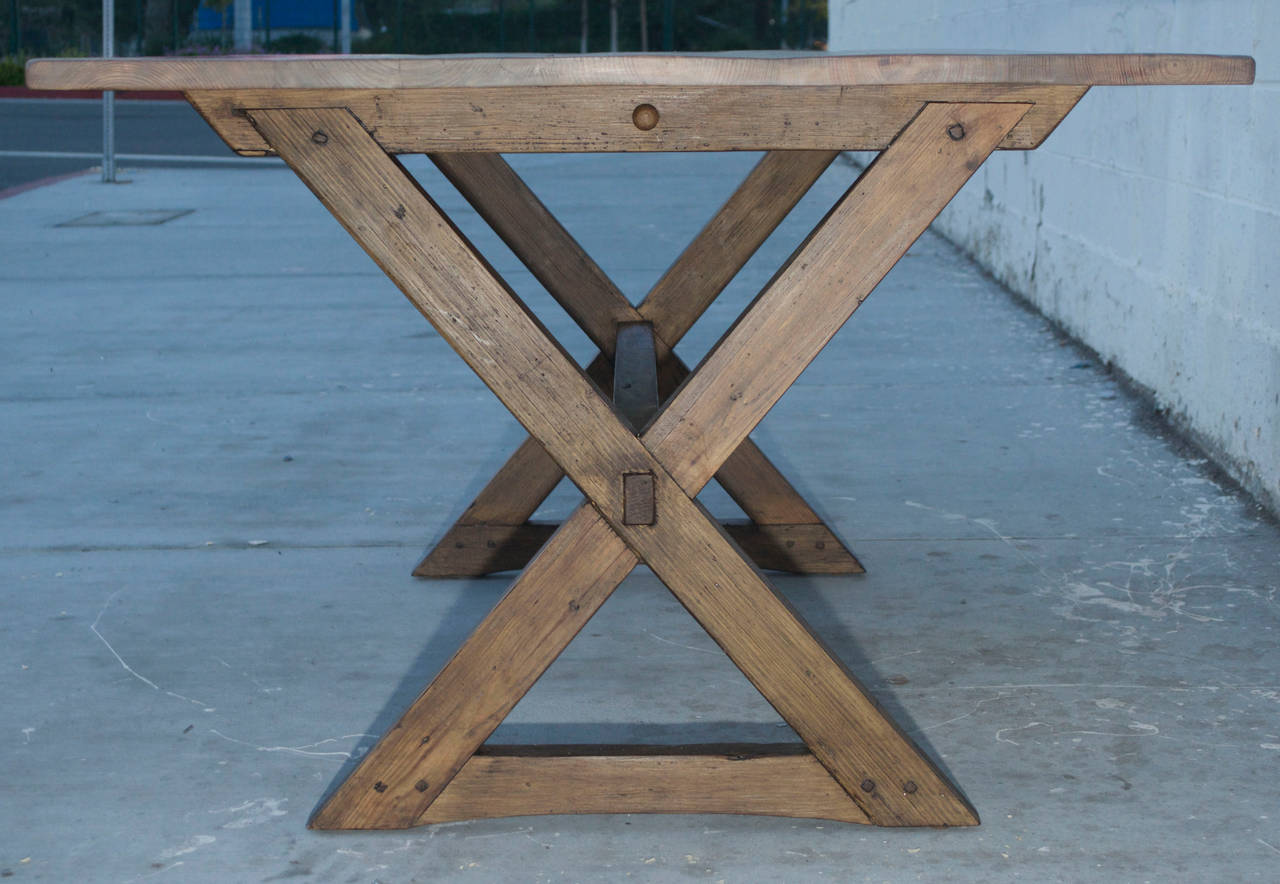 This reclaimed pine table is constructed using entirely traditional methods, no nails, screws or metal fasteners of any kind. The top can be taken off of the base by pulling out a round pin at the top center of each leg, right under the table top.
