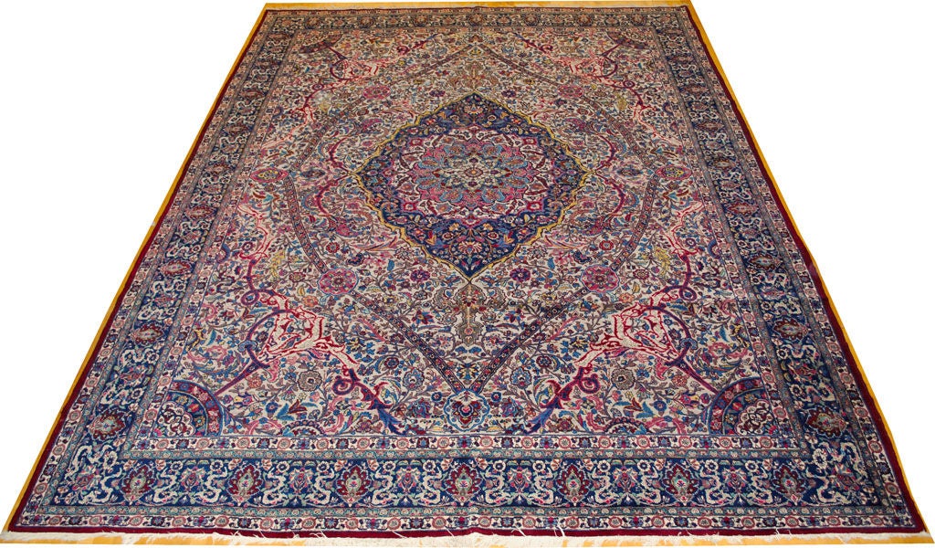 Persian Kerman Lavar (Kirman Levar) carpet with multicolored design and center medallion on light beige background with blue border. 