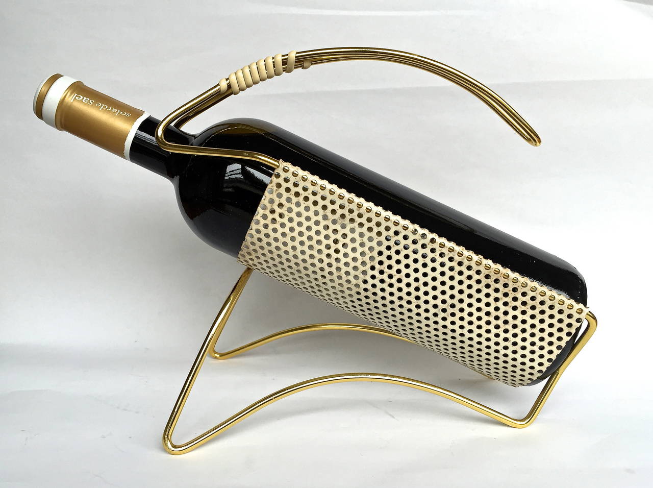 Gold-plated aluminum frame supports a white-painted pierced-steel cradle for wine decanting. Great 1950s French design after Mathieu Matêgot.