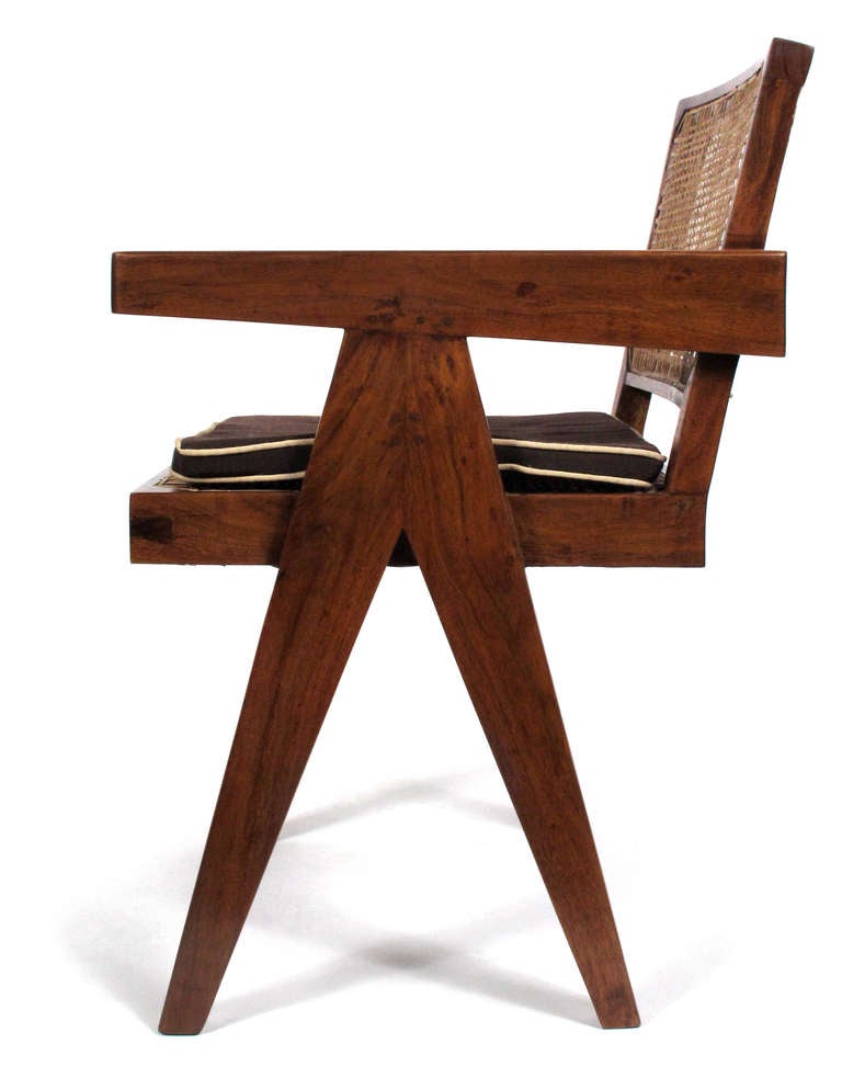 Fauteuil original en teck et osier avec coussin, conçu par Pierre Jeanneret. Il provient de la célèbre capitale moderniste de Chandigarh, en Inde, conçue par Le Corbusier, Jeanneret et leur équipe. 2 disponibles.