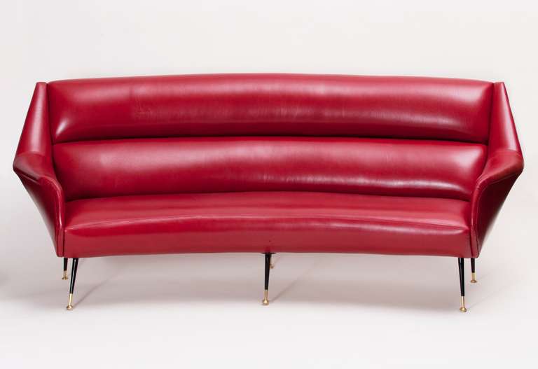 Curved, sexy and sleek modern sofa in the style of Gio Ponti in vibrant red leather, iron and brass.