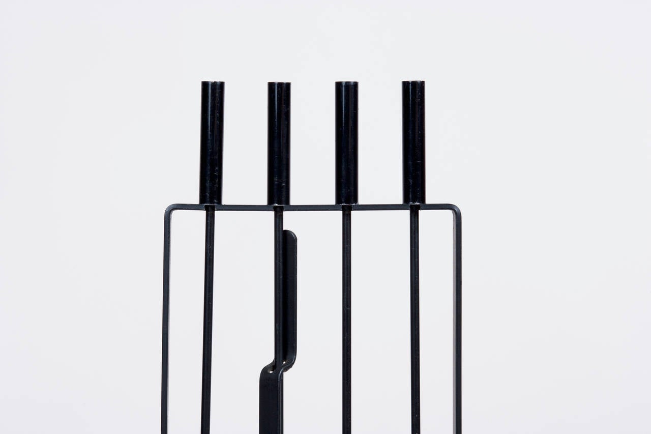 Architectural four-piece iron fire tool set by Pilgrim. Tools include a shovel, brush, poker and log grabber.