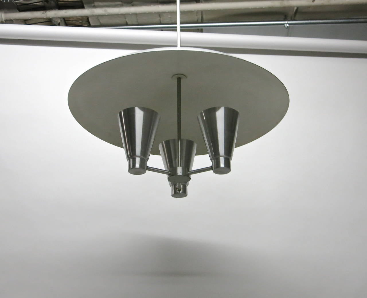 Ceiling light with three light diffusers and arched shade all in spun aluminum, designed by Edward Wormley.