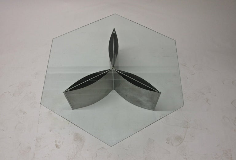 Coffee table in brushed aluminum with a hexagonal glass top.