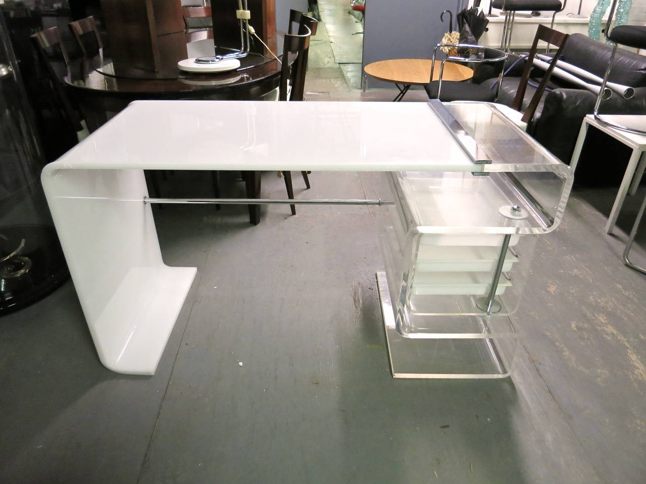 Desk in molded opaque white and clear lucite with three drawers that are encased in a clear lucite box that can be tucked into the desk or swing around for easy access.