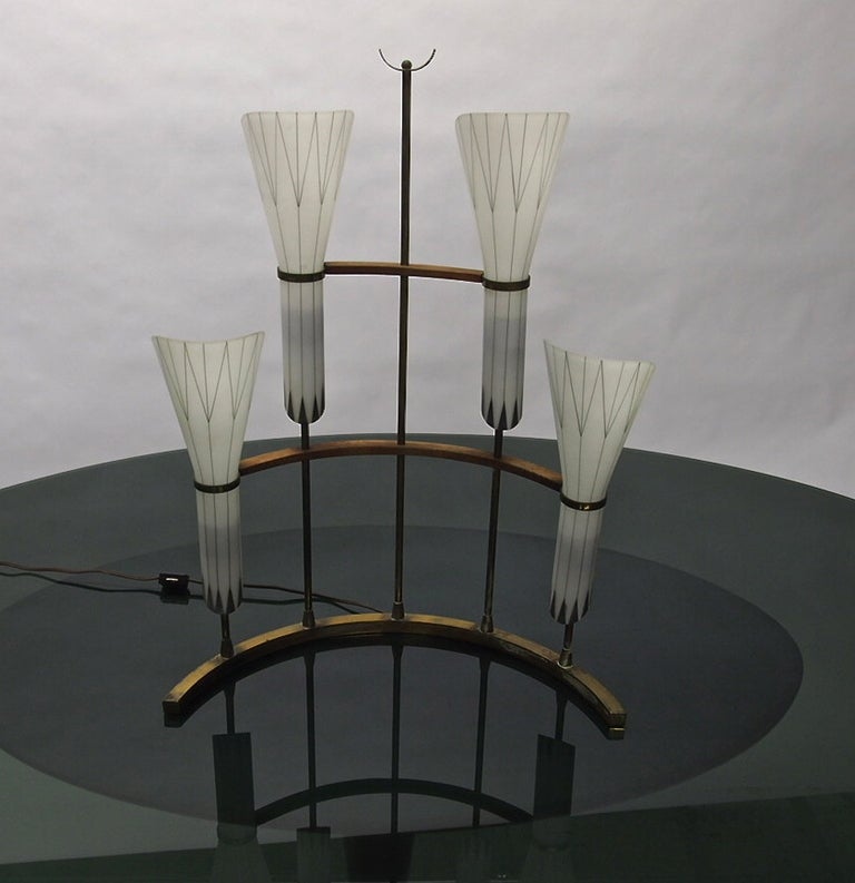 Table lamp with four hand blown hand painted cased glass shades that rest in bronze detailing and is supported by bronze brass and wood. The base is arched allowing the lamp to free stands.