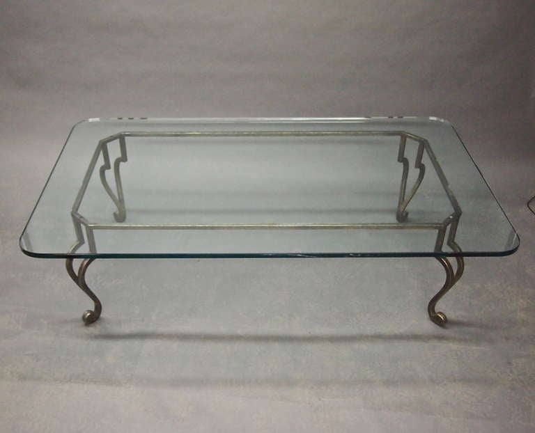 Coffe table In gilded metal is simple pure and elegant. A rectangular frame in gilt forged metal is made of four elegant legs a simple rectangular frame that supports a stron piece of glass with soft rounded corners