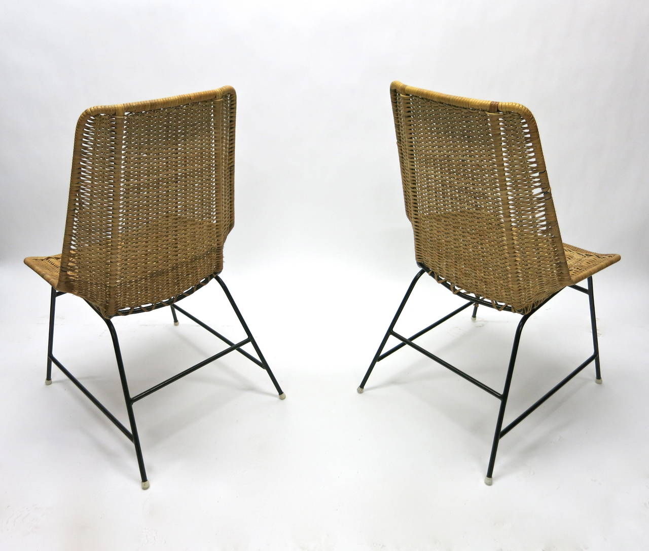 Pair of chairs each with tubular steel metal frames and woven caned seats.