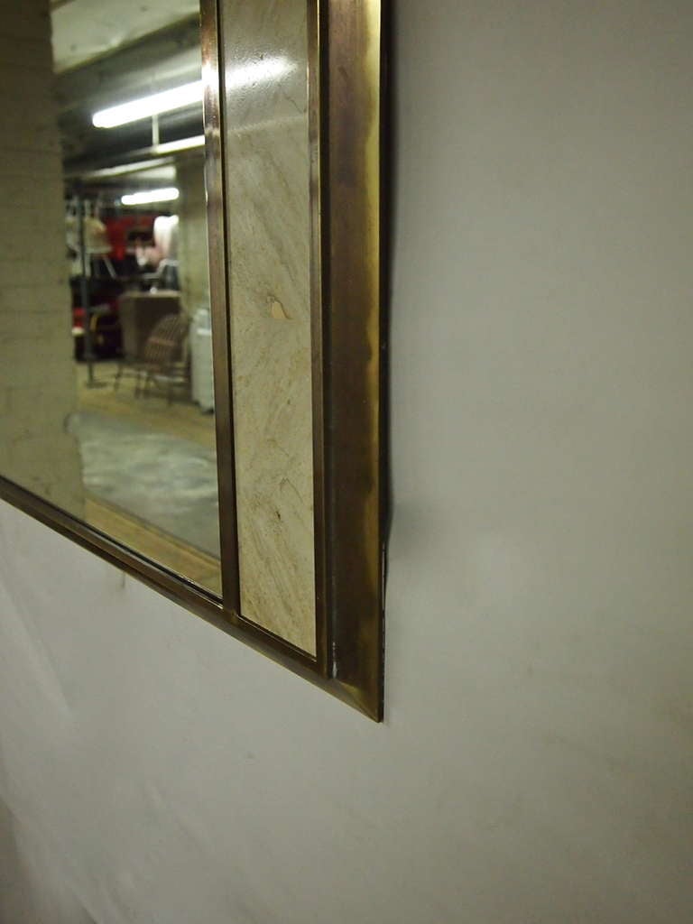Mirror framed in lacquered, patinated bronze. On each side there is a four inch strip of travertine that is also trimmed in a bronze patina. Marked 'Made in Italy'.