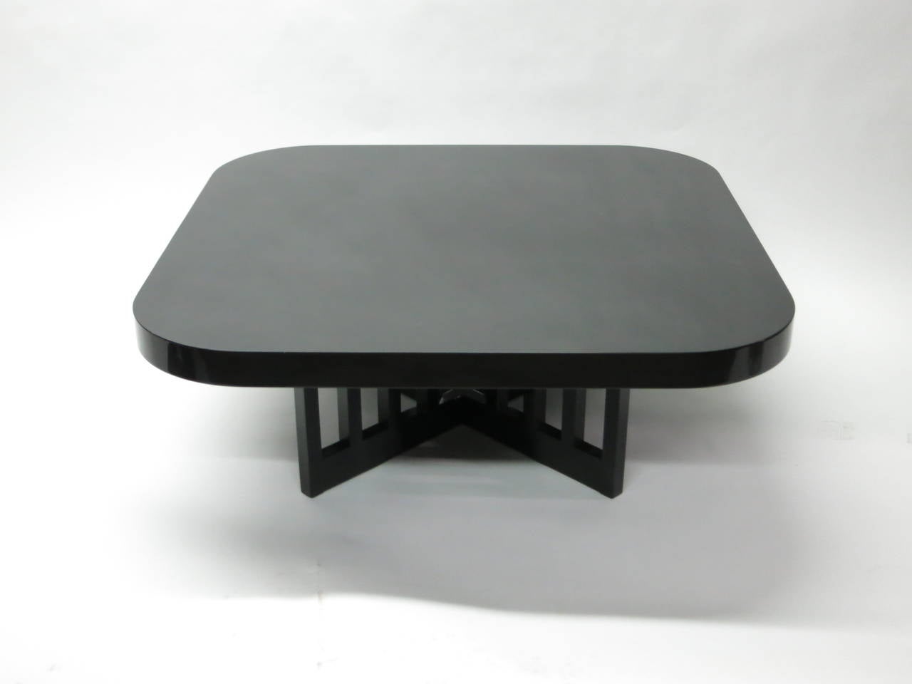 Coffee table with a 2 1/4 inch square top with rounded corners an X-shaped slatted base all in black lacquered wood designed Richard Meier for Knoll International in 1982. 
