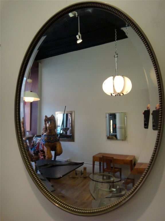 Mirror in solid nickel with a beaded detail that trims a beveled edge mirror.