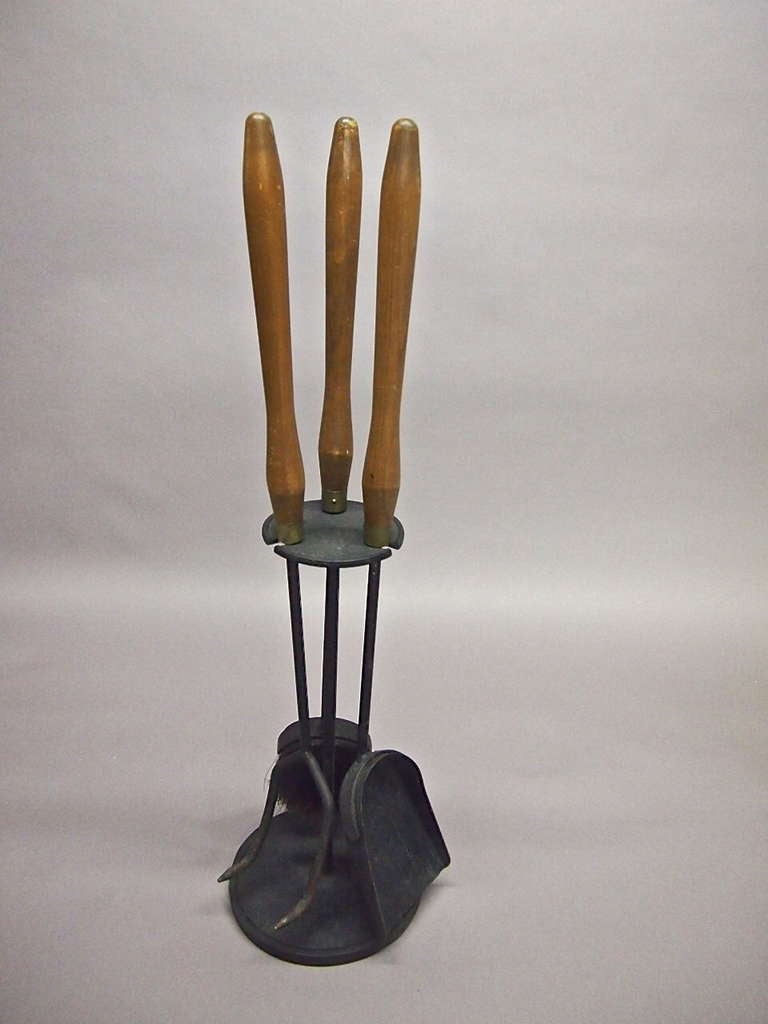 Free standing fire tools in enameled wrought iron and wooden handleswith brass detail. Signed Seymour.