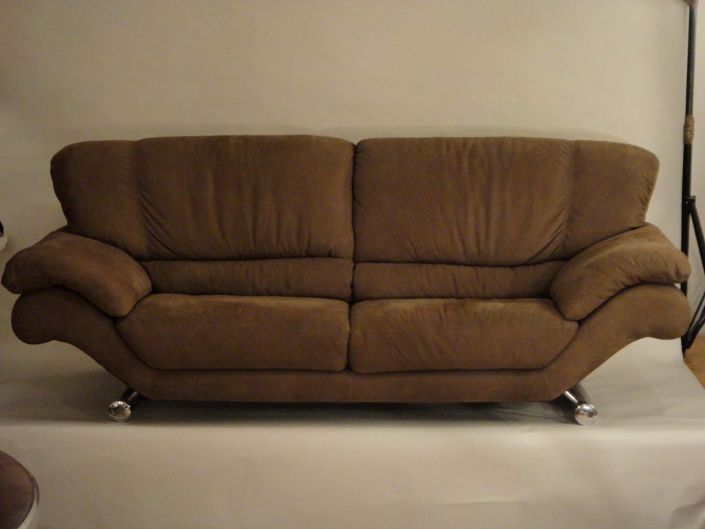 Sofa recently upholstered in brown leather with sewn in pillows on back and arms all resting on a tubular, chromed base. Designed by Vico Magistretti.