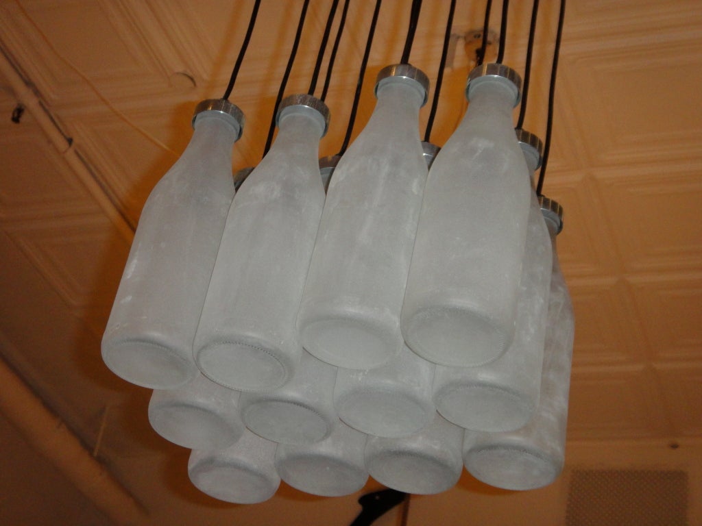 12 Milk Bottles 4x3 frosted glass with black adjustable wire that is covered by a  brushed metal canopy. Height of bottles can be adjusted to minimum of 24