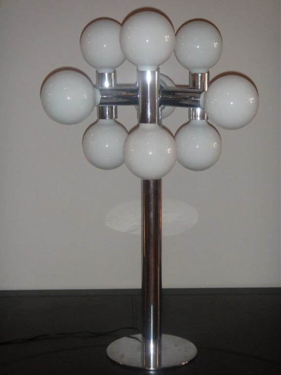 Lamp in polished metal has nine lights two vertical followed by one horizontal repeated three times with a 