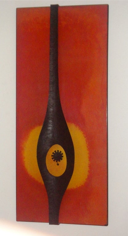 Wall mounted sculpture/art work with a central, abstract metal detail;hand hammered bronze