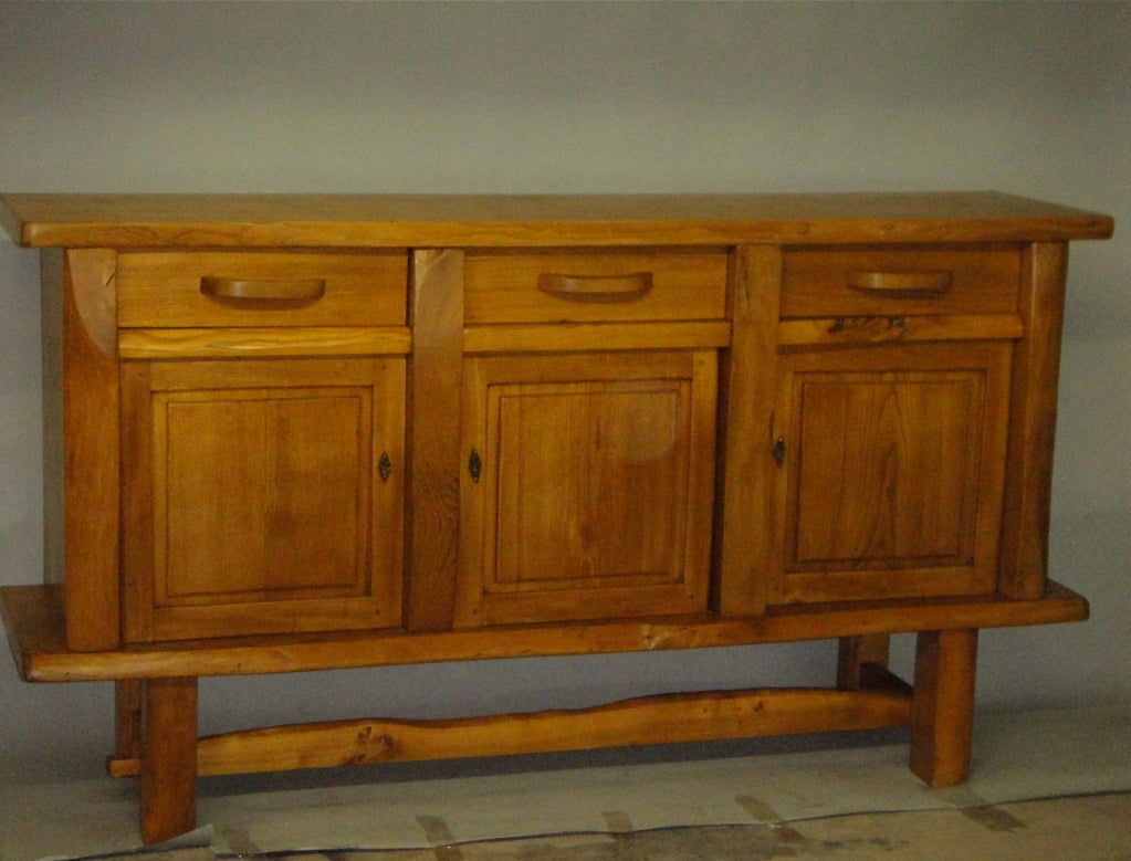 Le meuble en chêne d'après Chapo a trois tiroirs au-dessus de trois portes et des bords de forme libre