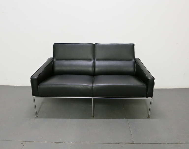 Pair of vintage, model 3302 two-seater sofas designed by Arne Jacobsen and manufactured by Fritz Hansen for the Royal Hotel in Copenhagen. Newly upholstered in black leather and their metal frame is in excellent vintage condition. A third available