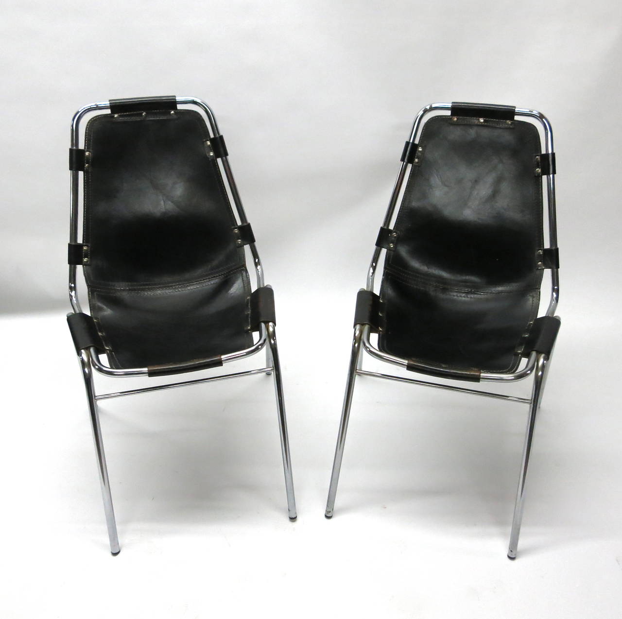 Pair of chairs all original with tubular chrome base and frame that supports a  leather seat and back. The leather is stitched together joining the seat and back and attached to the frame by eight leather straps that wrap the around the frame and