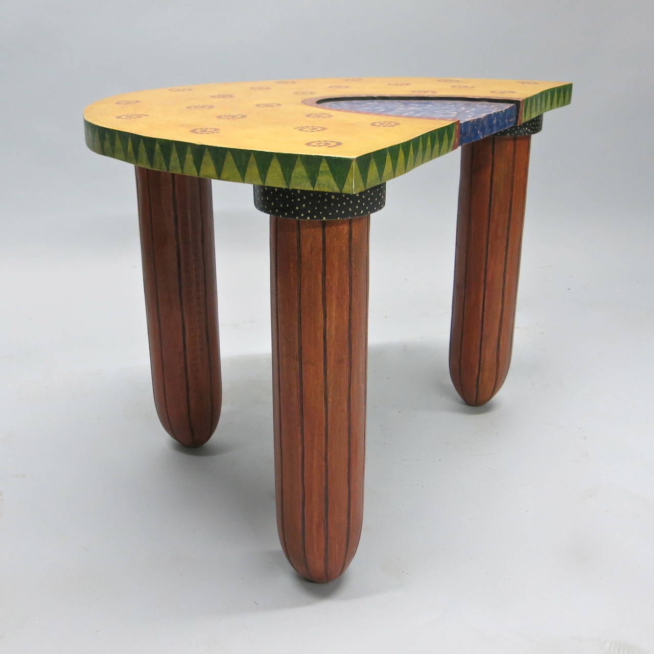 Pair of wooden side tables by Fabiane Garcia with nice artistic and quality characteristics that embody very good use of color. Each table has three legs and a non-perfect demilune shaped top that is accented nicely with a carved texture center in