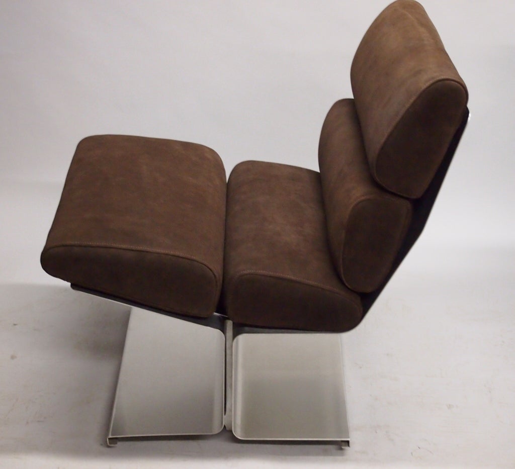 Pair of chairs that have a stainless steel base and back, with newly upholstered brown suede cushions.