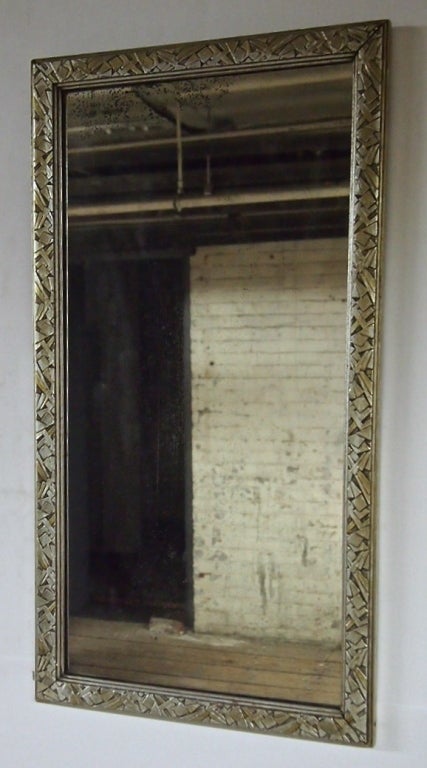 Mirror in silver leafed hand carved wood in a deco motif with original label and original finish. Similar version listed for over 2000 Who knows
