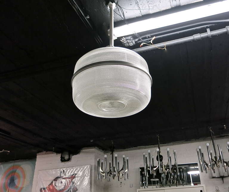 Large ceiling fixtures in holophane glass with a metal band around the center and a 6