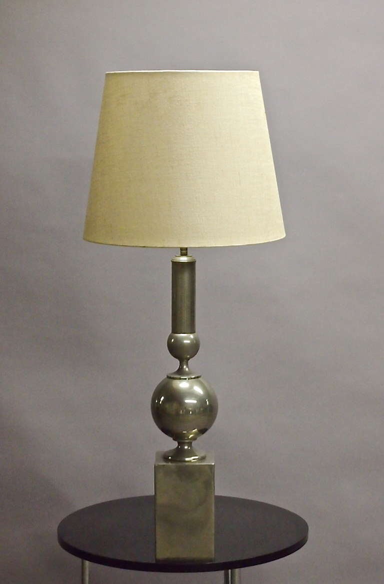 Table lamp in nickel with a fabric covered shade.