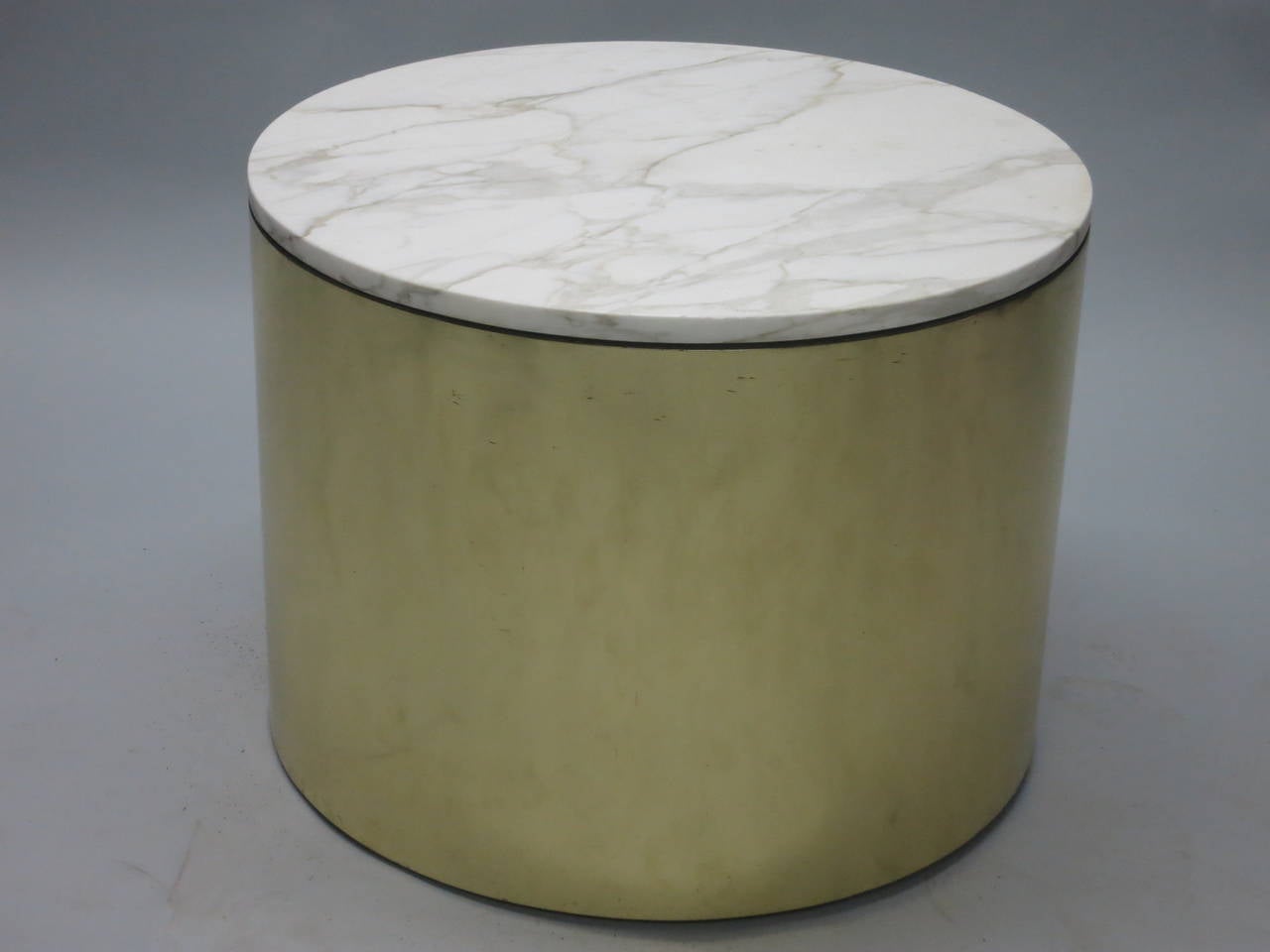 Two round side or coffee tables with brass frames and 3/4 inch Italian white and grey marble tops. The tables are elevated with adjustable feet are both in original and very good condition with some minor surface marks on the brass. No chips on the