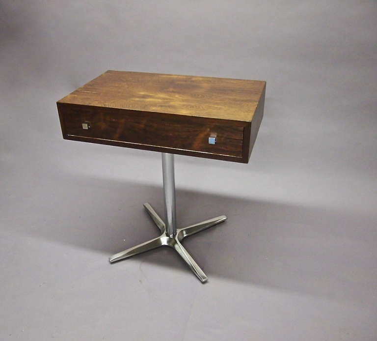 Classic splayed, solid polished steel legs support a petit top with one drawer.