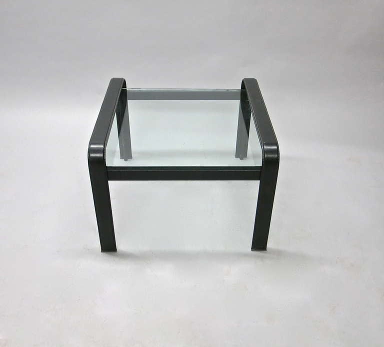La table est constituée d'un cadre en acier recouvert de cuir noir qui supporte un plateau en verre d'une épaisseur de 2,5 cm, reposant juste un peu plus bas que les côtés. matteograssi est estampillé dans le cuir de l'un des plateaux  jambe. 