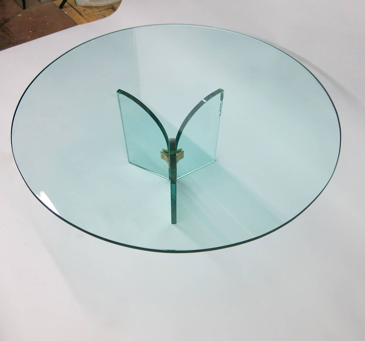 Coffee tables with round glass tops supported by three 3/4 inch thick pieces of arched glass joined with solid brass hardware. Both tops have pencil point edges and are ale 3/4 inch thick.