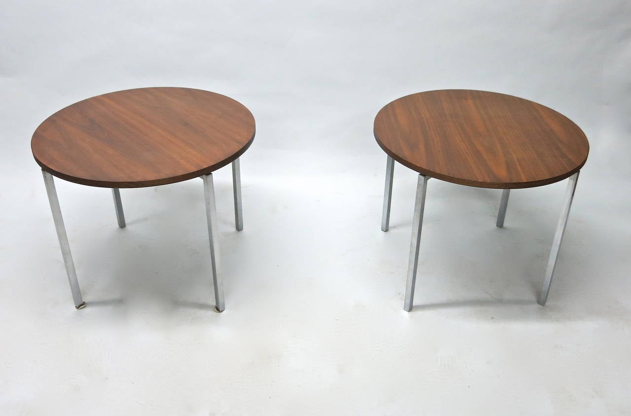 Pair of round walnut tables both with four legs and a floating walnut top. The legs are nickel plate. The top is slightly elevated above the base.