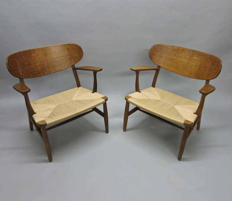 Pair of CH-22 chairs by Hans Wegner for Carl Hansen & Son in oak and paper cord.