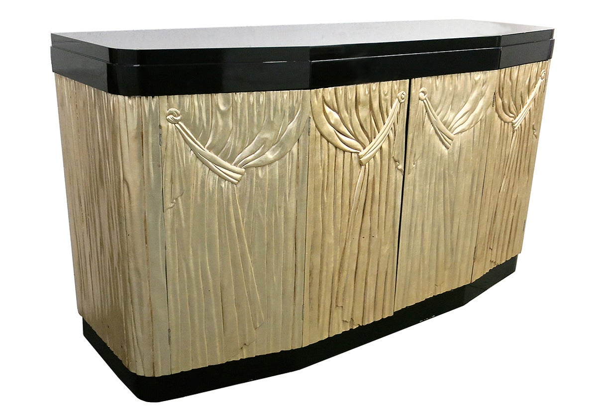Buffet has two hand-carved, bow front, silver leafed, accordion doors. Each door is hinged in the center allowing it to fold when open to half its size allowing easy access to the interior that consists of sliding drawers on each side each with
