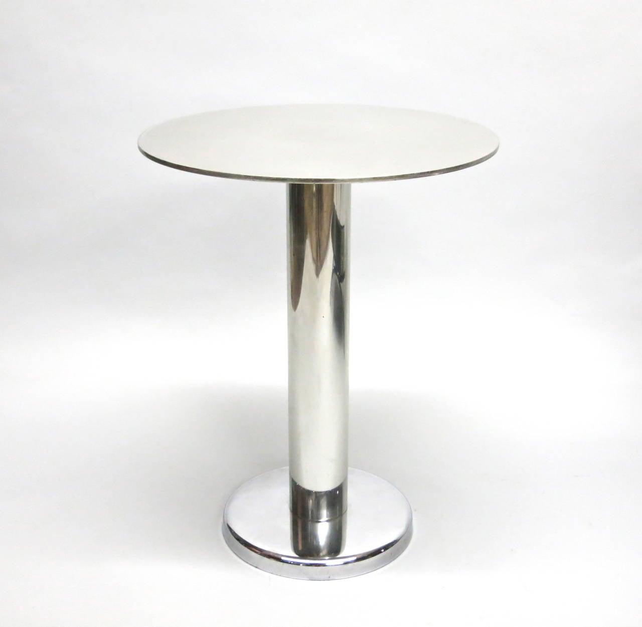 Set of four polished steel side tables with strong a deco design. Each table has a 3 inch tubular pedestal in the center that supports a 1/8 inch thick top with a 16 inch diameter. The base rises one inch off the floor with a round edge and a 10