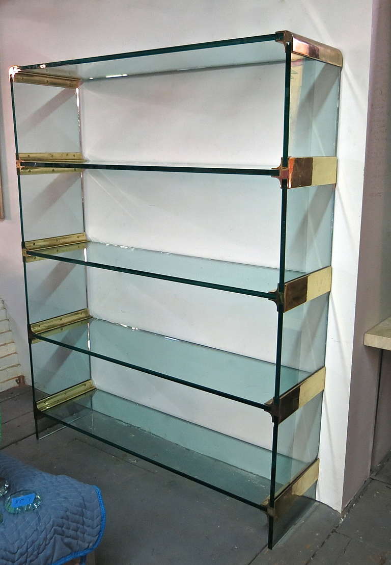 Shelving Unit made of with 3/4 inch glass and brass plated solid steel hardware.