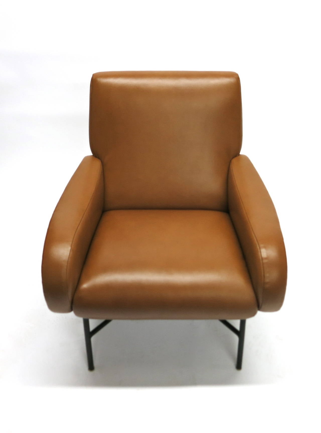 Lounge chair has been covered in brown leather with arms seat and back that closely resembles Marco Zanuso Lady's chair. The base has four legs an X stretcher in black enameled steel.