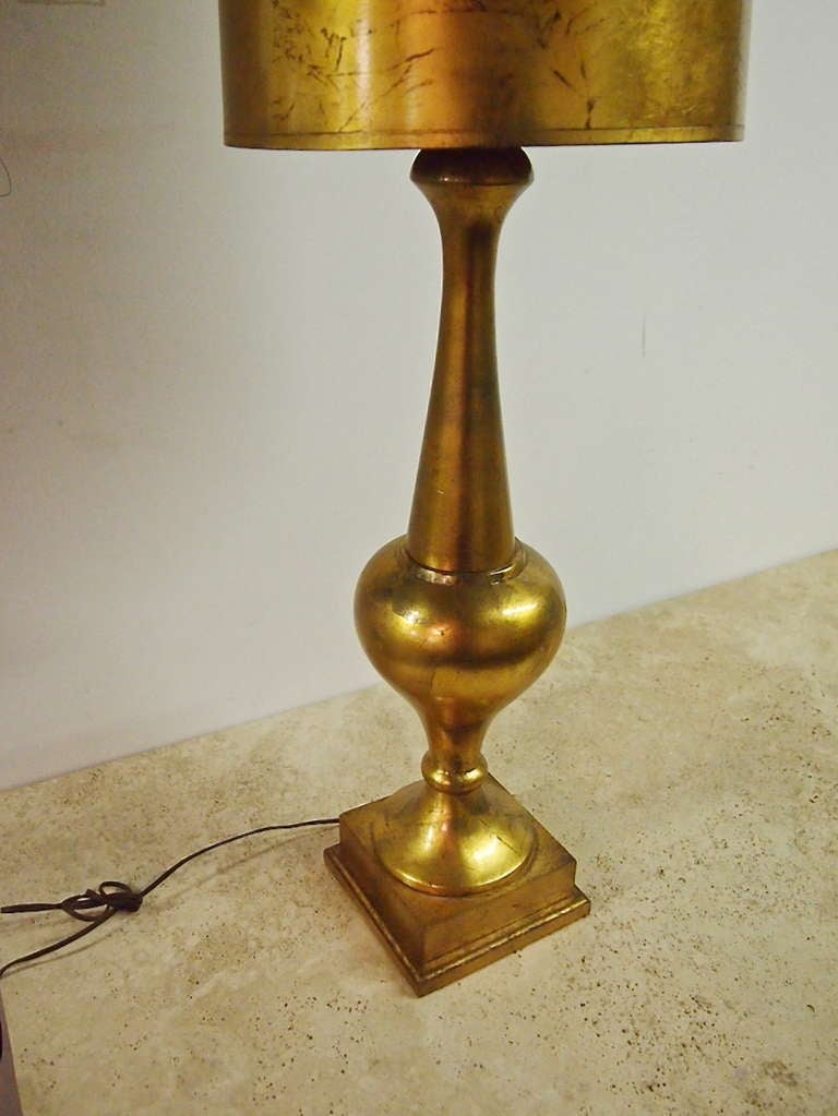 Tall gilded table lamp with matching shade in the manner of James Mont.