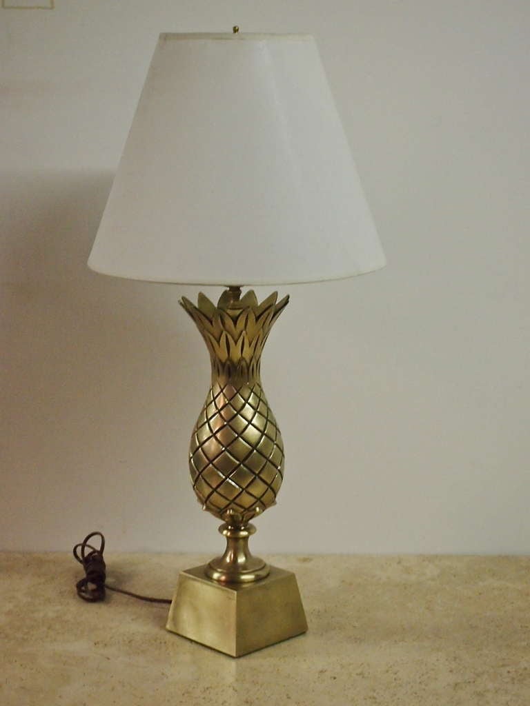 Pair of brass table lamps in the form of a pineapple sitting on a tapered, pedestal base.