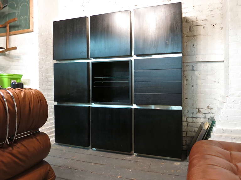 Wall unit consists of nine square cabinets that are separated by brushed steel.