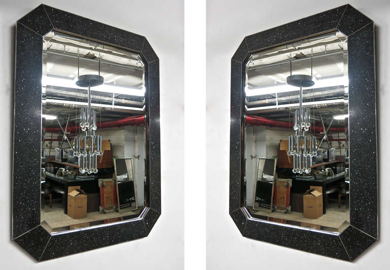 Pair of beveled Mirrors surrounded by black speckled, faux stone. The mitered stone is framed in 1/2 inch polished steel with 1/4 inch inlay between the miters.