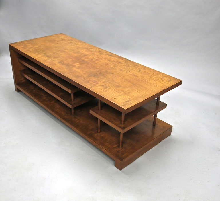 La table basse en bois d'après Maxime Old a un plateau en placage de noyer à allumettes qui est soutenu par des chevilles rondes qui traversent les trois étagères suspendues jusqu'en bas, permettant à chaque étagère de flotter.